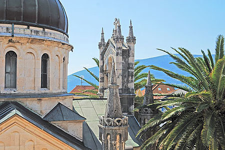 Close view of Savina Monastery stone domes with the bay and mountains behind